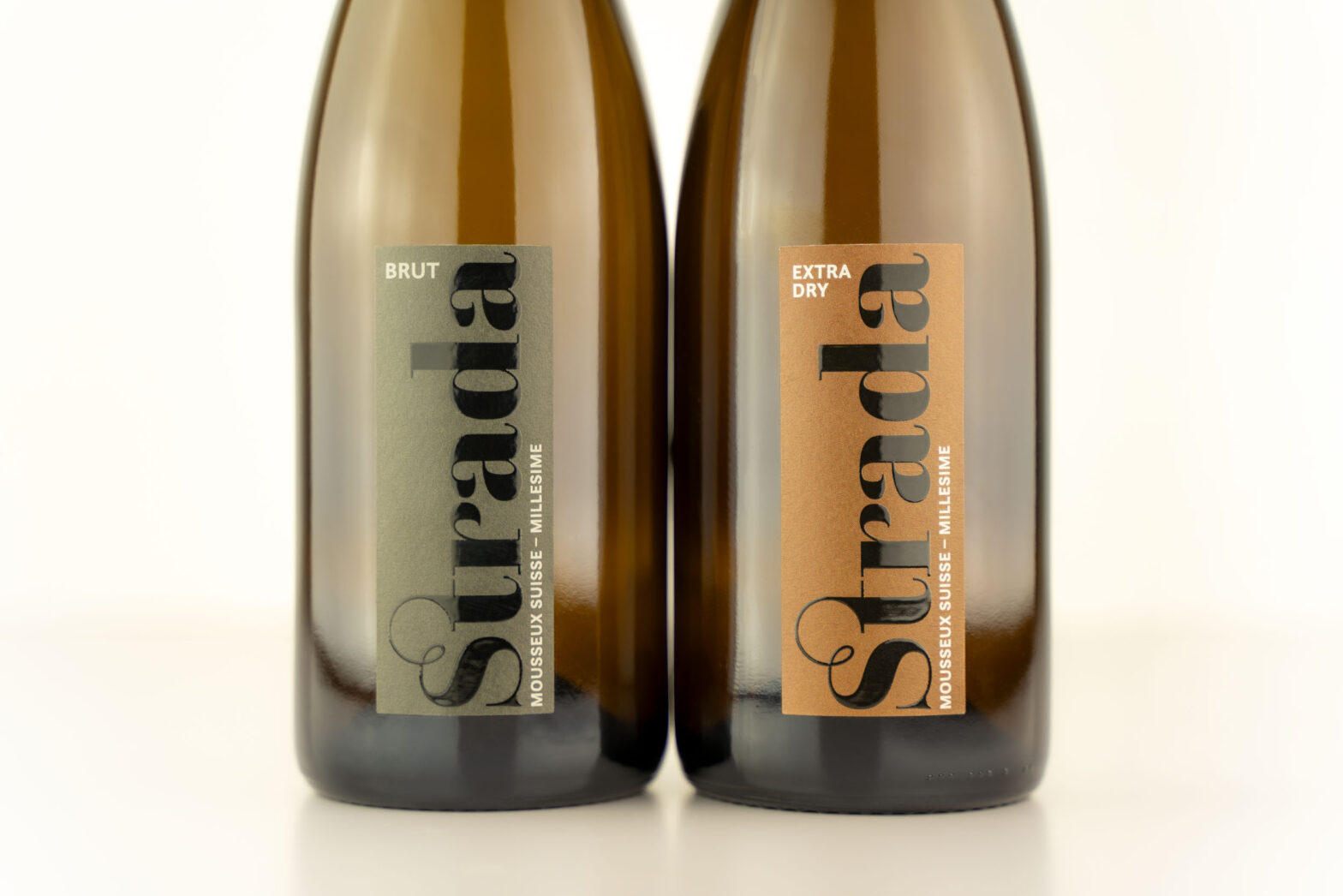 Der untere Teil von zwei Flaschen Schaumwein: Strada Extra Dry und Strada Brut